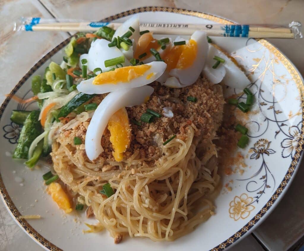 Mee Kola Noodle Salad in Krong Battambang mee kola noodle salad with boiled egg, peanuts, and fresh herbs in Krong Battambang, Cambodia