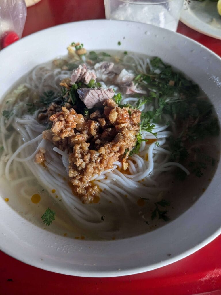 Yunnan noodles in Laos with spicy meat sauce, fermented beans, and pickled mustard