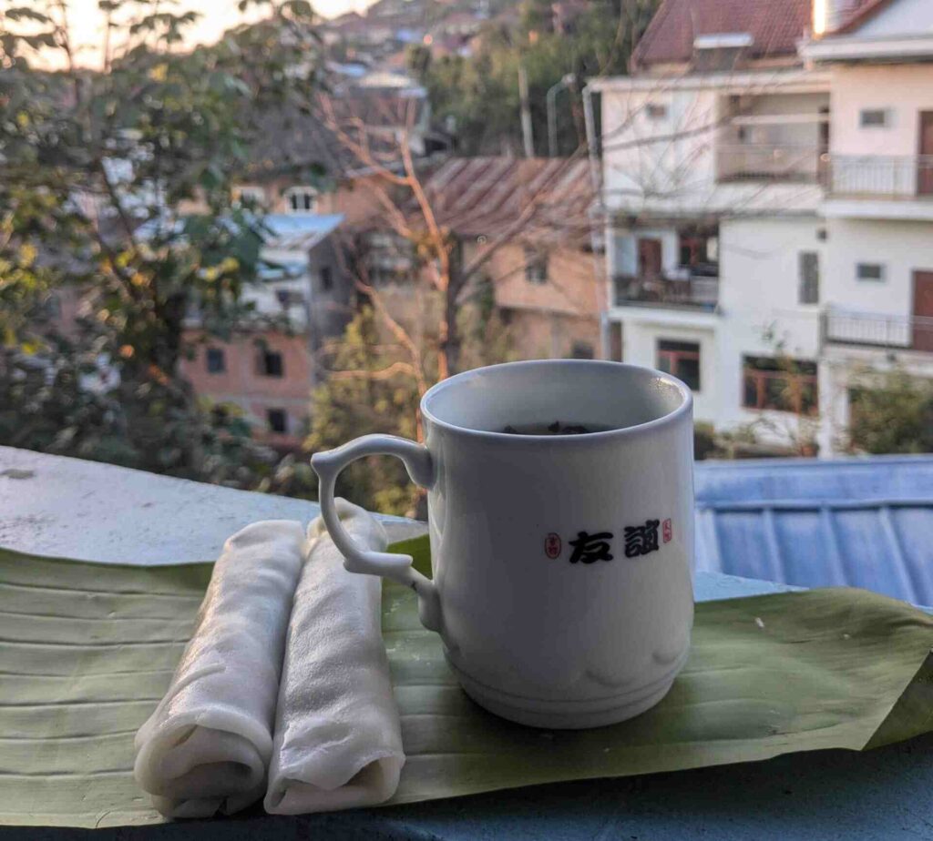Tea and Lao banh cuon on a balcony with a mountain view in Phongsaly Old Town