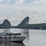 Krabi limestone cliffs and river at sunrise with longtail boats