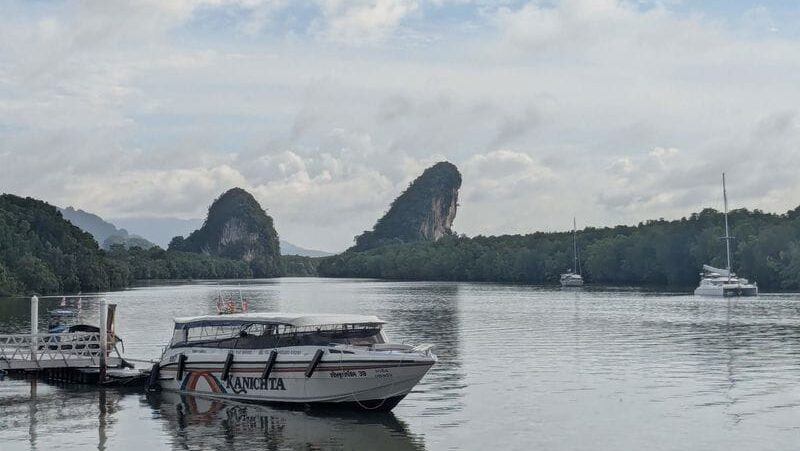 Krabi limestone cliffs and river at sunrise with longtail boats